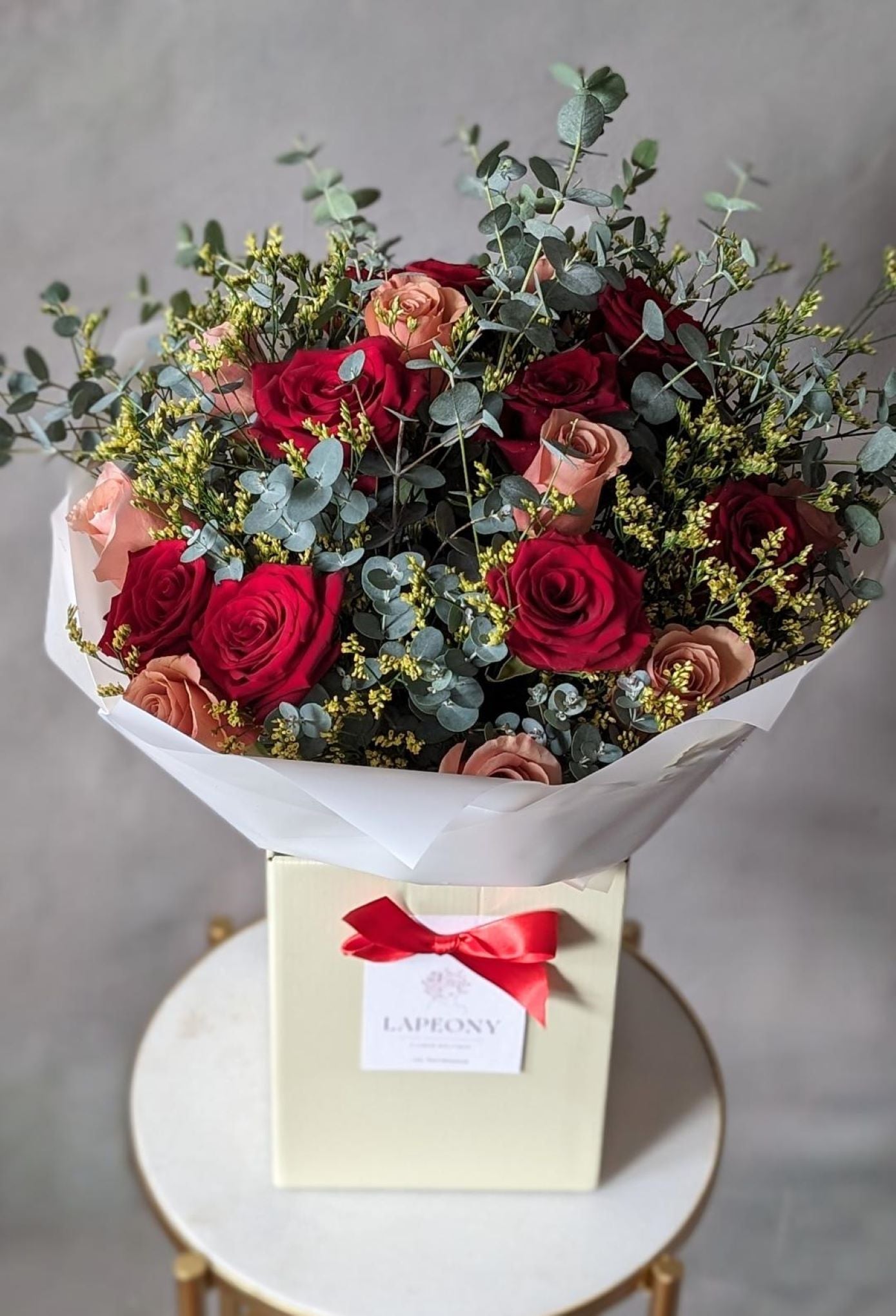 Large Red and Caramel color Rose bouquet with Eucalyptus and Limonium presented in Flower Box